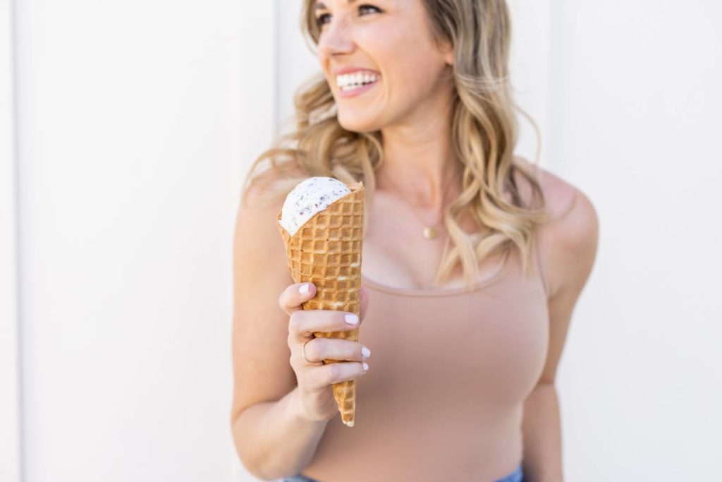 Kellen holding an ice cream cone, smiling off camera during her brand shoot.