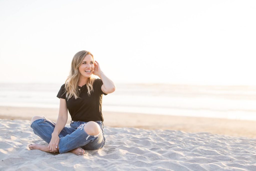 Kellen posing on a white, sandy beach in San Diego during her brand photoshoot for Meg Marie Photography.