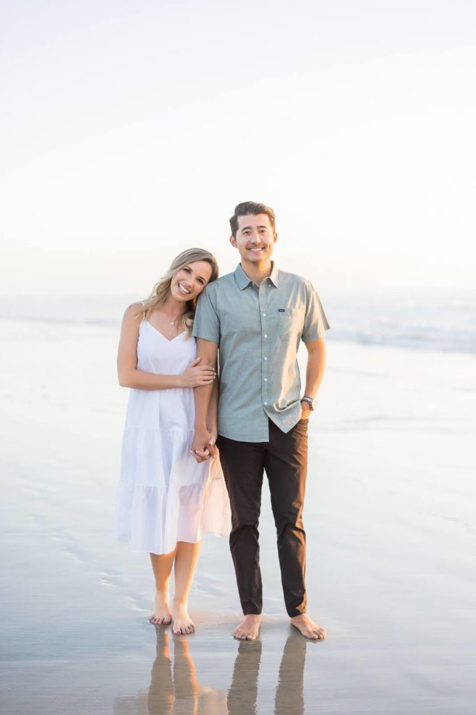 Kellen McAvoy with her hubby posing on a beach in San Diego for her brand photoshoot by Meg Marie Photography.