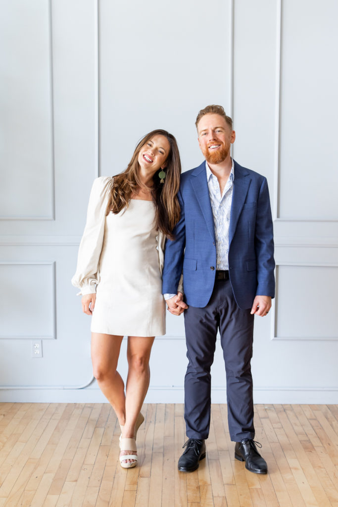 Woman and a man holding hands, looking at the camera during their personal brand photoshoot. 