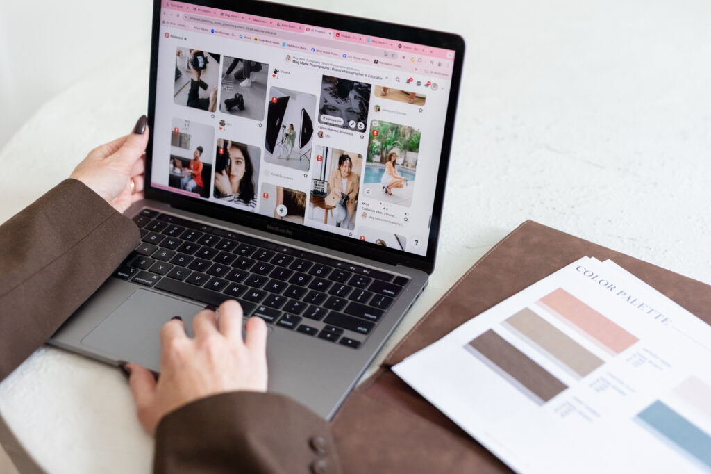 Laptop displaying Pinterest inspiration and a color palette document, representing the creative process behind a custom brand identity and visual strategy