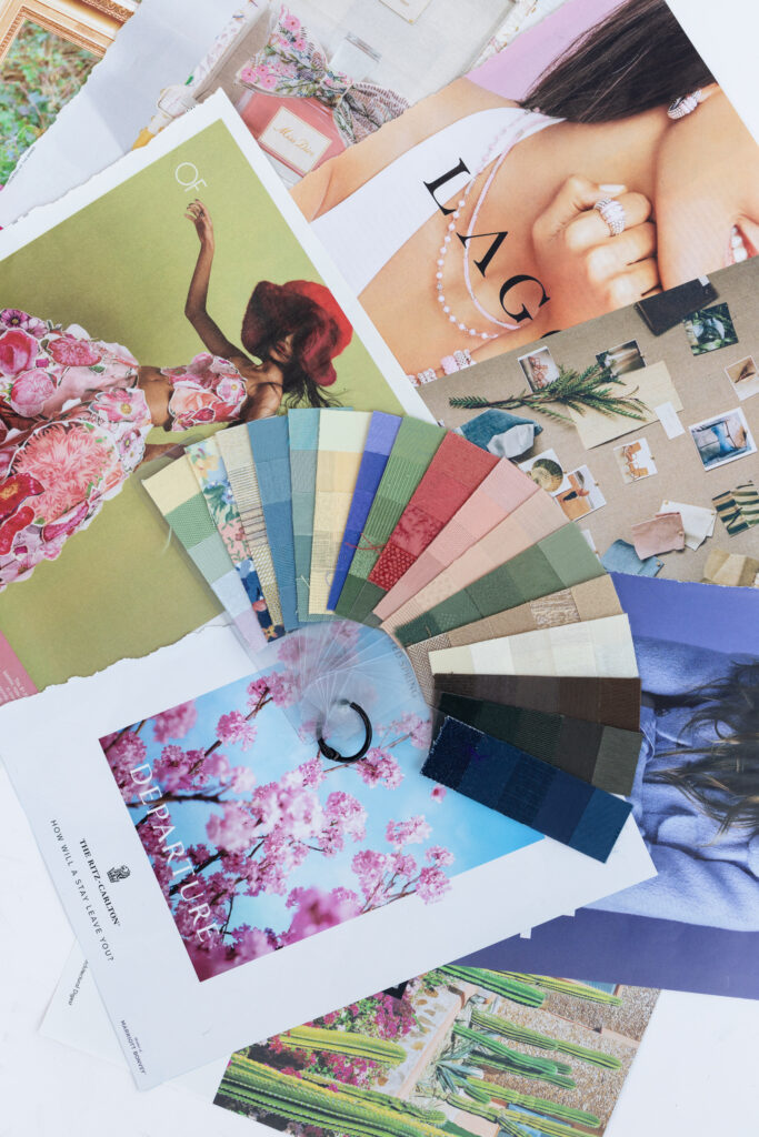 Flat lay of fashion magazine tear sheets with a fan of fabric color swatches, illustrating style inspiration and personal brand color analysis for visual branding.