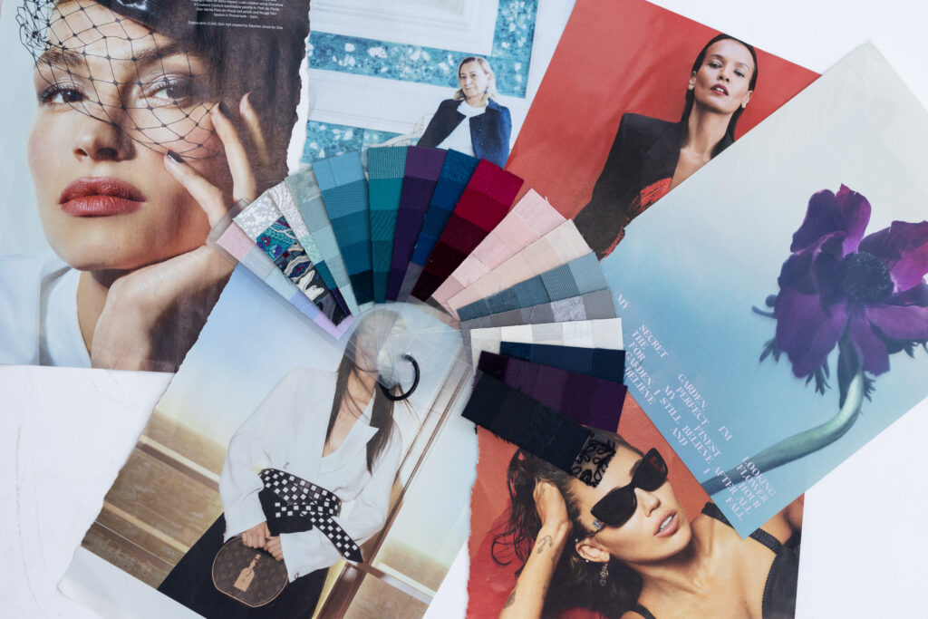 Flat lay of fashion magazine tear sheets with a fan of fabric color swatches, illustrating style inspiration and personal brand color analysis for visual branding.
