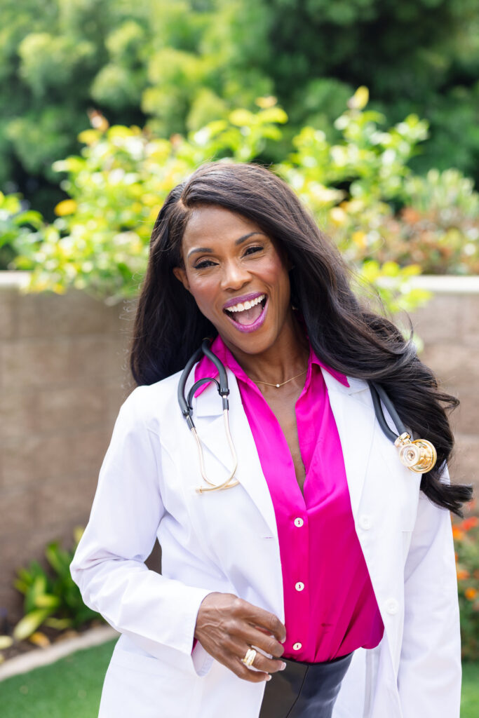 Female doctor wearing a white lab coat over a pink collared button-up shirt, portraying professionalism and approachable healthcare branding